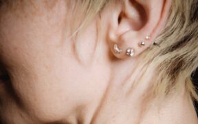 Bilden visar en person med många piercing placeringar i örat. Du kan få hjälp med öronhåltagning i Stockholm och hitta smycken som Huggies, Hoops och olika Labrets.